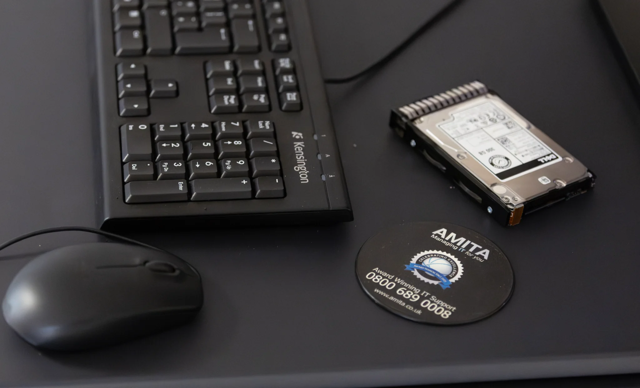 amita disc on working desktop beside a keyboard